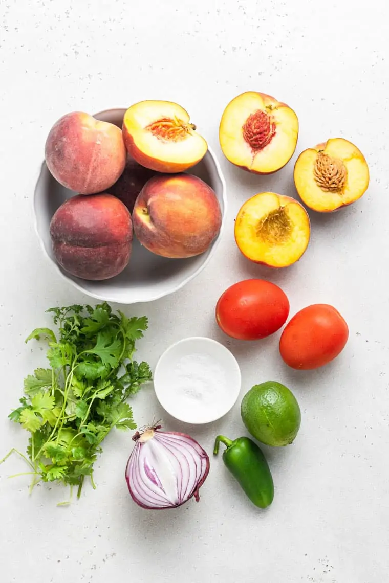 ingredients for peach salsa with tomato, jalapeno, lime and red onion