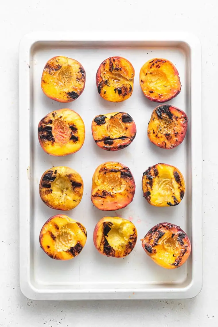 baking sheet with grilled halved peaches