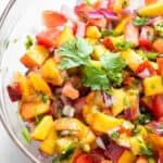 close up on peach, tomato and onion salsa