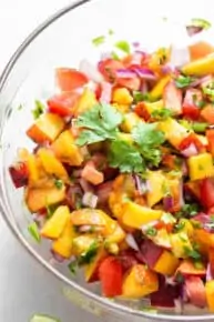 close up on peach, tomato and onion salsa