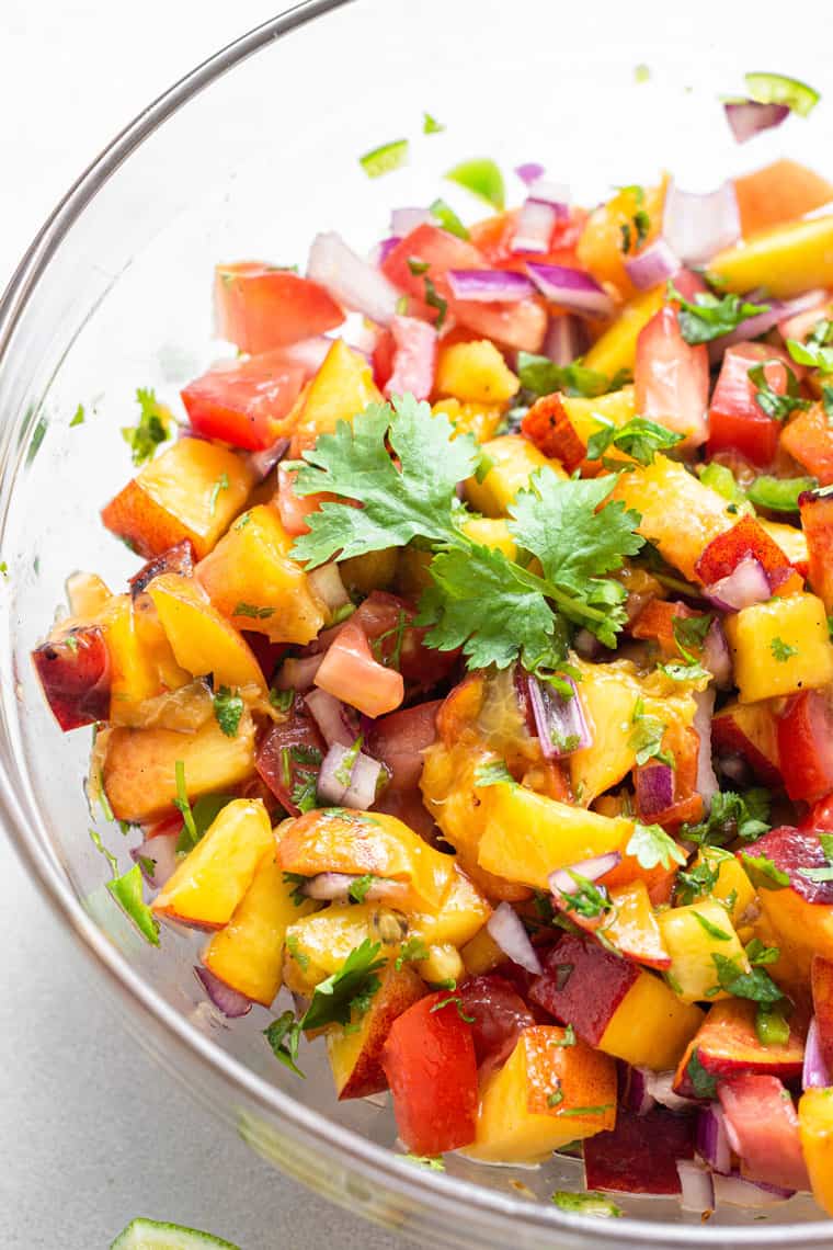 close up on peach, tomato and onion salsa