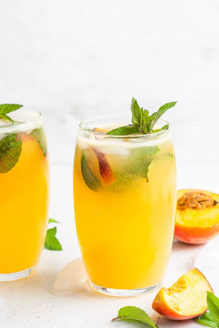 two glasses of peach mojitos with mint