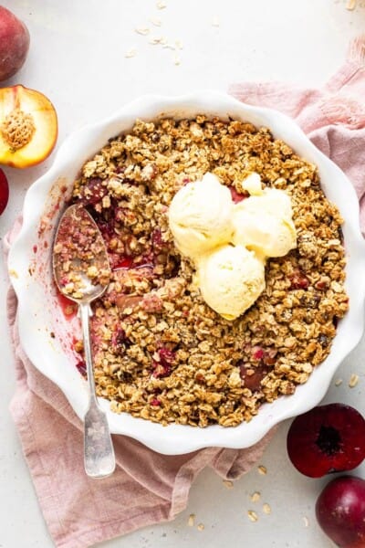 overhead of a fruit and quinoa crumble with three scoops of white ice cream on top