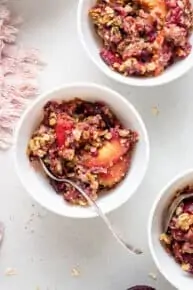 small bowl of plum and peach cumble with quinoa