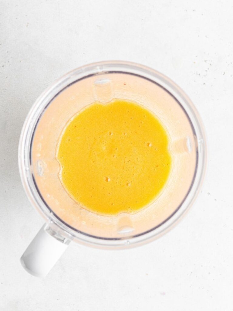 This peach mojito recipe is made with peach purée, white rum, lime, and fresh mint, sweetened with honey for a light, fizzy summer cocktail. Fresh peach purée in a blender.