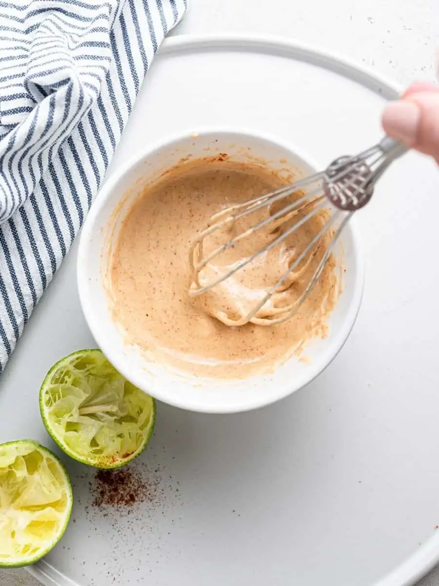 Whisking tahini sauce in small bowl