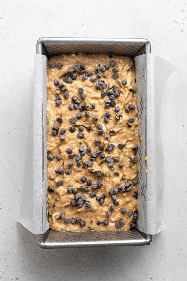 overhead of a baking pan with uncooked zucchini bread dough topped with chocolate chips