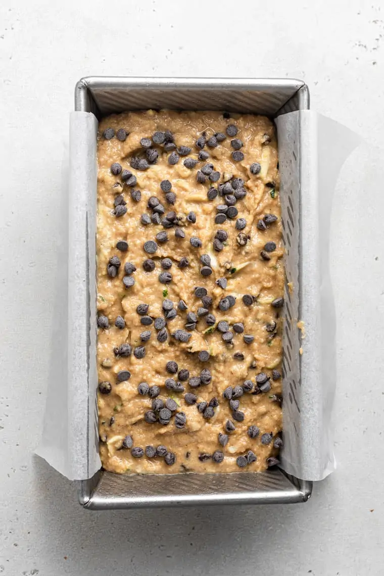 overhead of a baking pan with uncooked zucchini bread dough topped with chocolate chips
