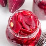 jar of sliced pickled beets with peppercorns