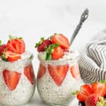 two glass jars of overnight quinoa with fresh strawberries
