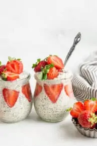 two glass jars of overnight quinoa with fresh strawberries