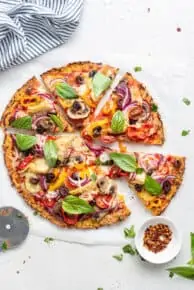 pizza with colorful vegetables cut into slices