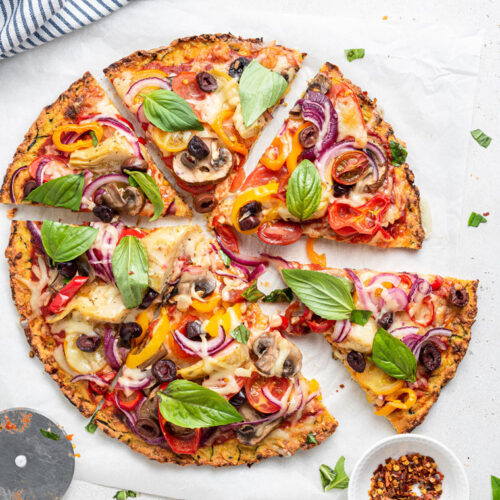 pizza with colorful vegetables cut into slices
