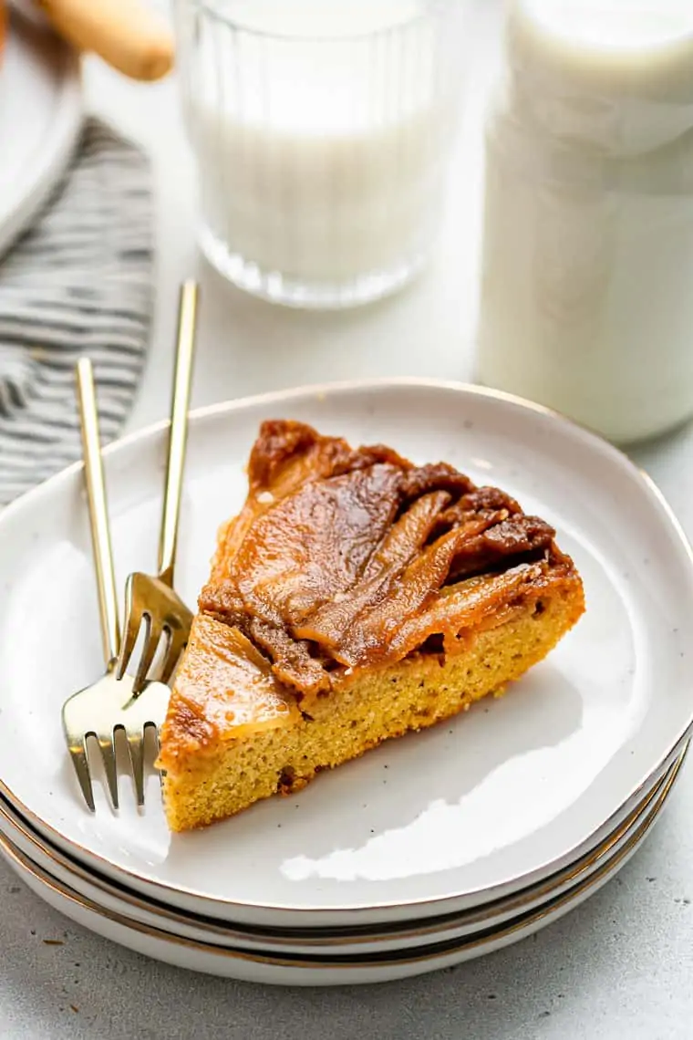 slice of gluten free apple upside-down cake on a stack of plates