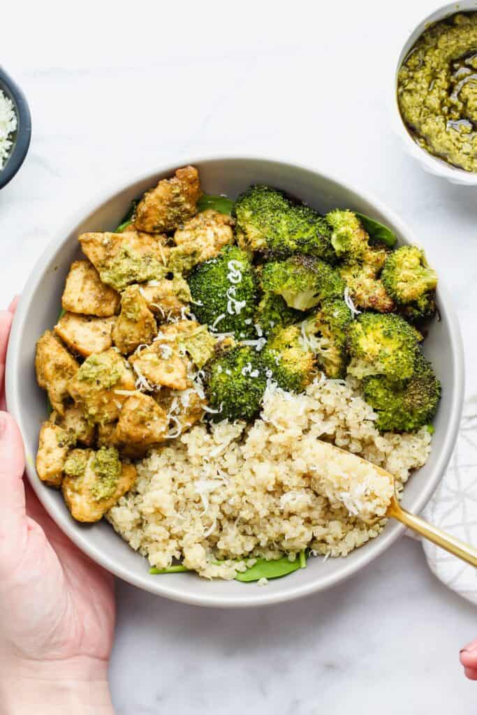 overhead of quinoa bowl with pesto, chicken and broccoli