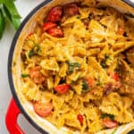 red pot of sun dried tomato pesto pasta with cherry tomatoes