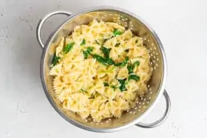 colander with cooked bowtie pasta