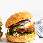 black bean burgers on a bun with onion, tomato and lettuce