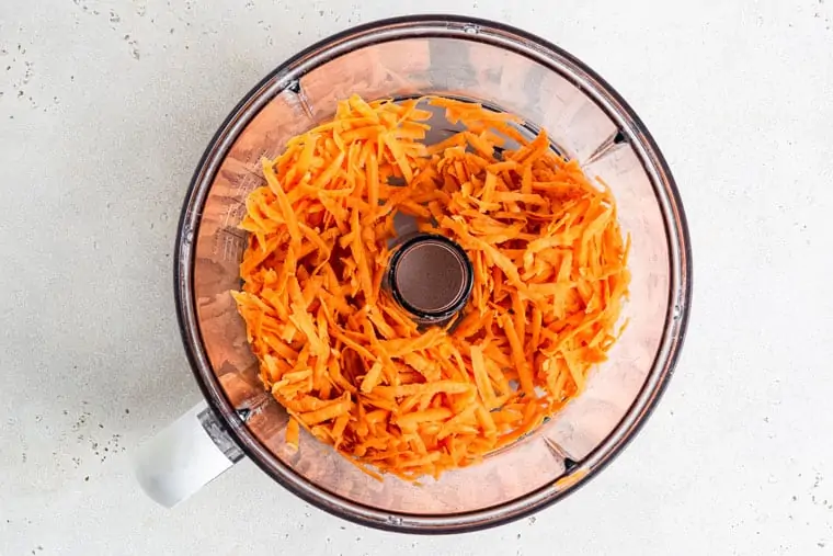 food processor with shredded raw sweet potato