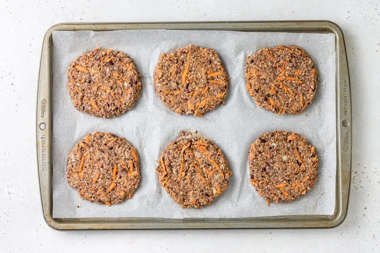 uncooked black bean sweet potato burgers on a baking sheet