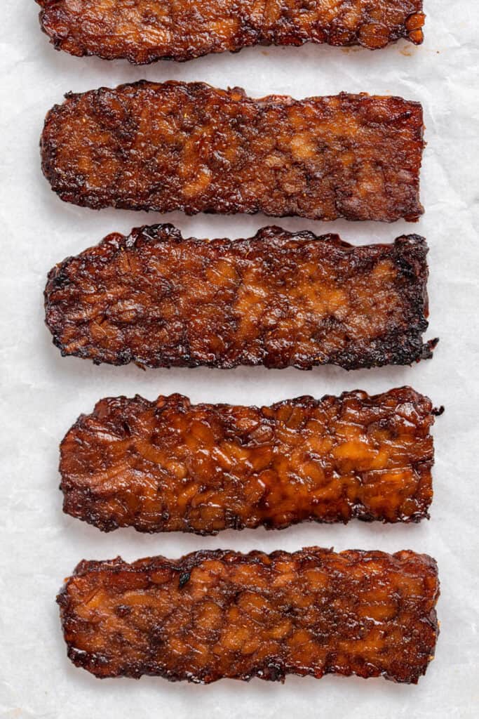 close up of four strips of cooked tempeh bacon