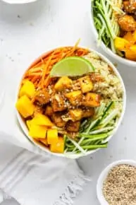 overhead of teriyaki quinoa bowls with mango, tofu and sesame dressing