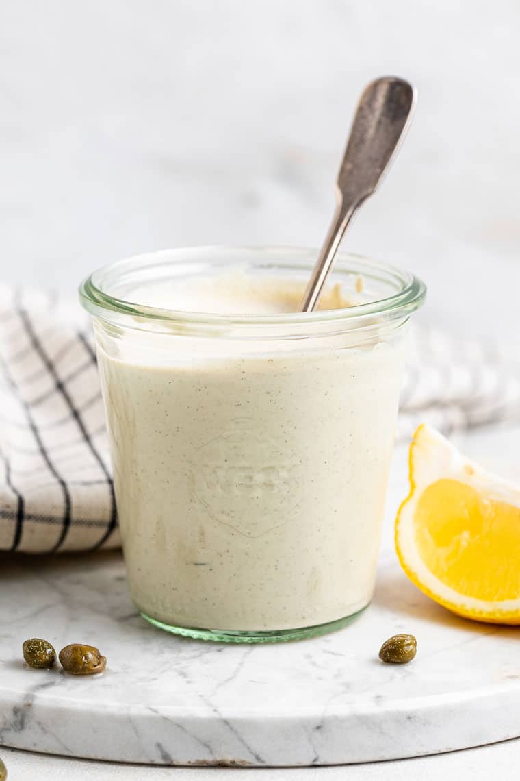 This easy vegan Caesar dressing recipe is the best plant-based replacement in a Caesar salad, with tahini, lemon juice, capers, and mustard. jar of vegan dressing with capers and lemon