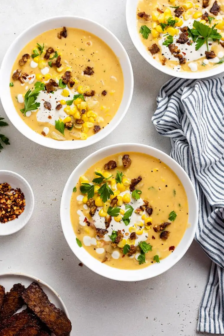 three bowls of corn chowder with cashew cream, fresh corn and herbs