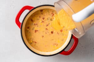 adding creamed corn chowder into pot to make vegan corn chowder recipe