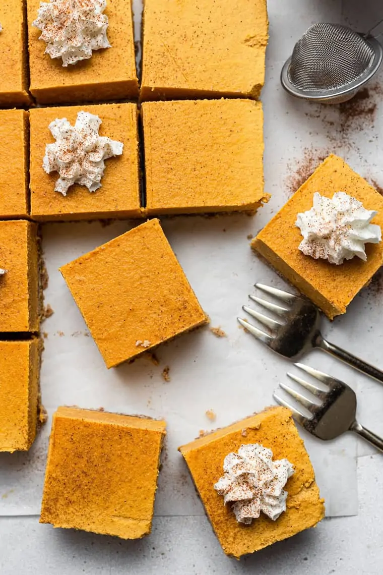 overhead of pumpkin cheesecake bars with whipped cream