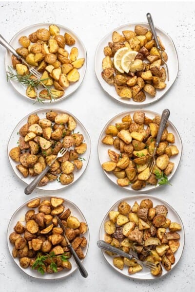 Overhead view of roasted potatoes on six plates