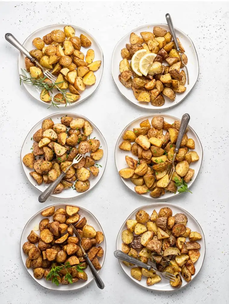 Overhead view of roasted potatoes on six plates