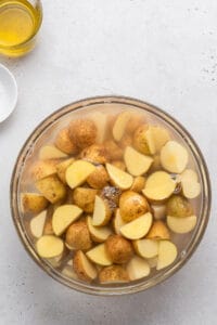 Overhead view of potatoes soaking in bowl of water