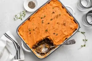 vegan shepherd's pie in a baking dish with a slice removed