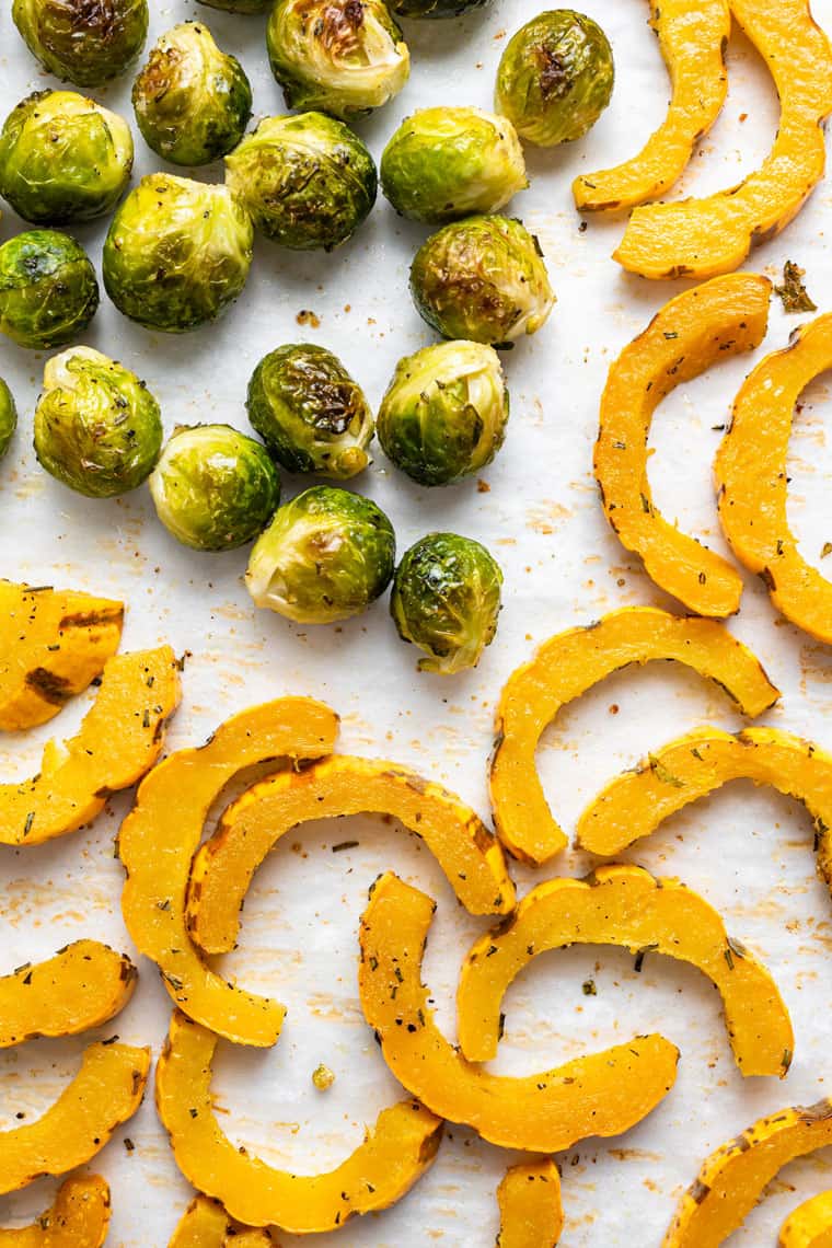 roasted squash and brussels on a baking sheet