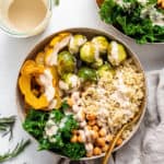 overhead of a bowl of quinoa, squash and brussels sprouts with dressing