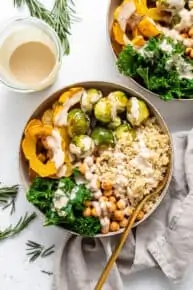 overhead of a bowl of quinoa, squash and brussels sprouts with dressing