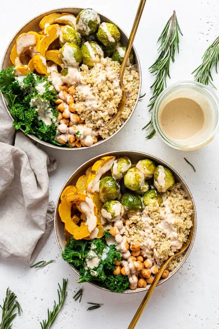 two bowls of quiona, vegetables and chickpeas with dressing