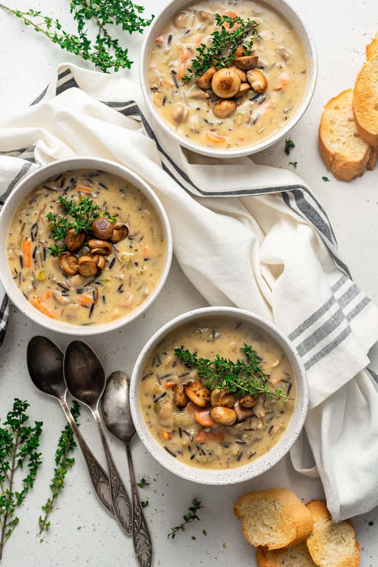 three bowls of creamy wild rice soup with mushrooms