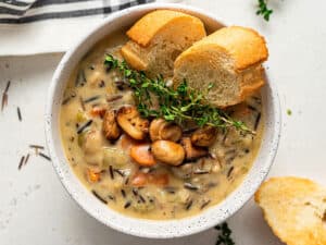 bowl of mushroom soup with thyme and bread
