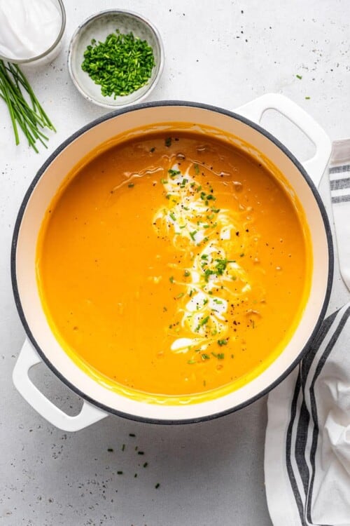 pot of sweet potato soup with cream and chives