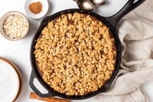 Overhead view of a baked pumpkin crisp in a cast iron skillet.