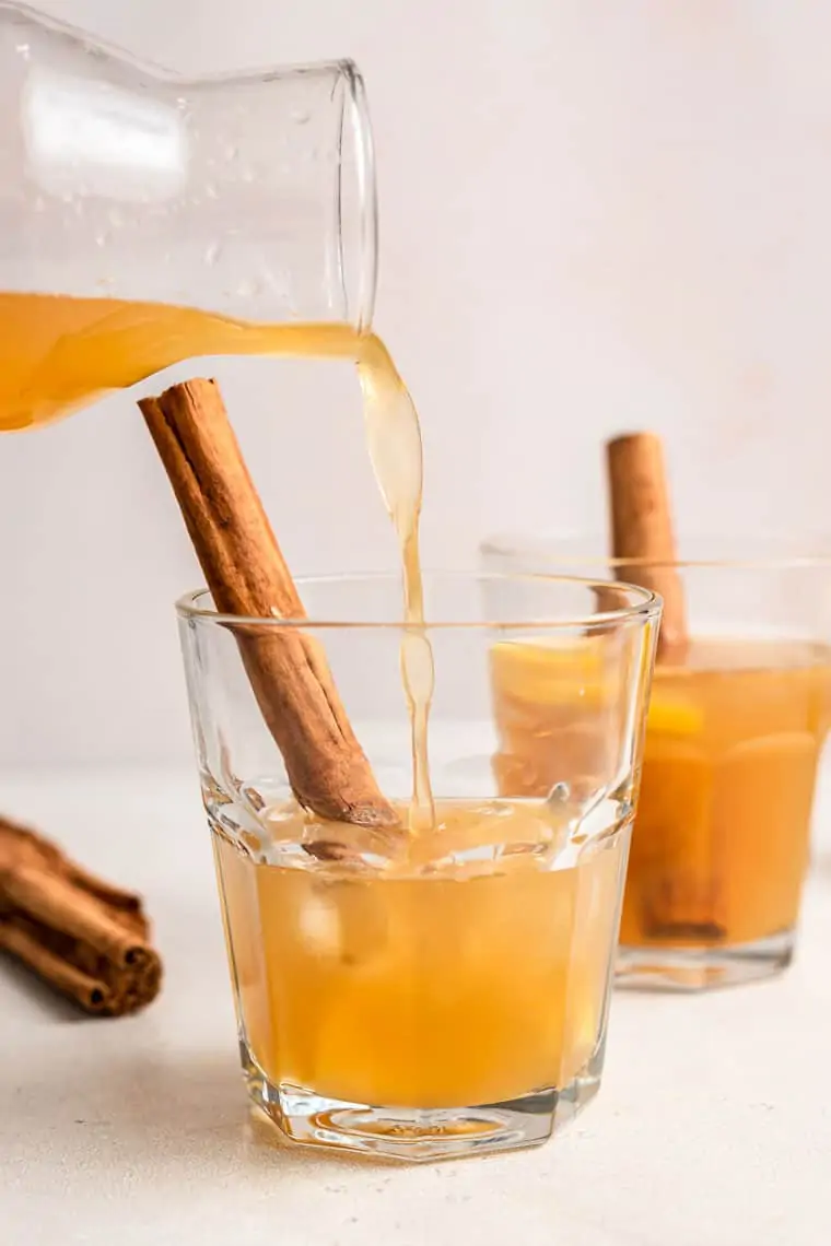 pouring lemon bourbon cocktails into a glass