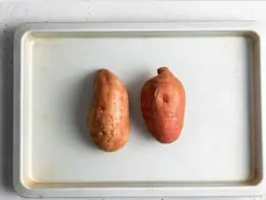 baking sheet with two sweet potatoes