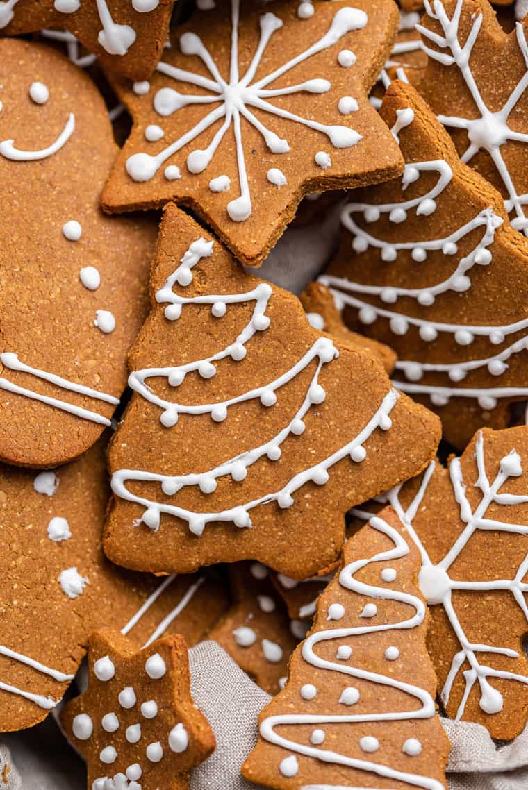 How to make vegan gingerbread cookies for the holidays! Bonus: they’re also gluten-free, which means you’ll have a treat everyone can enjoy. close up on gluten-free gingerbread christmas cookies with icing