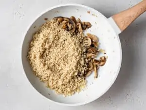 skillet with cooked quinoa and mushrooms