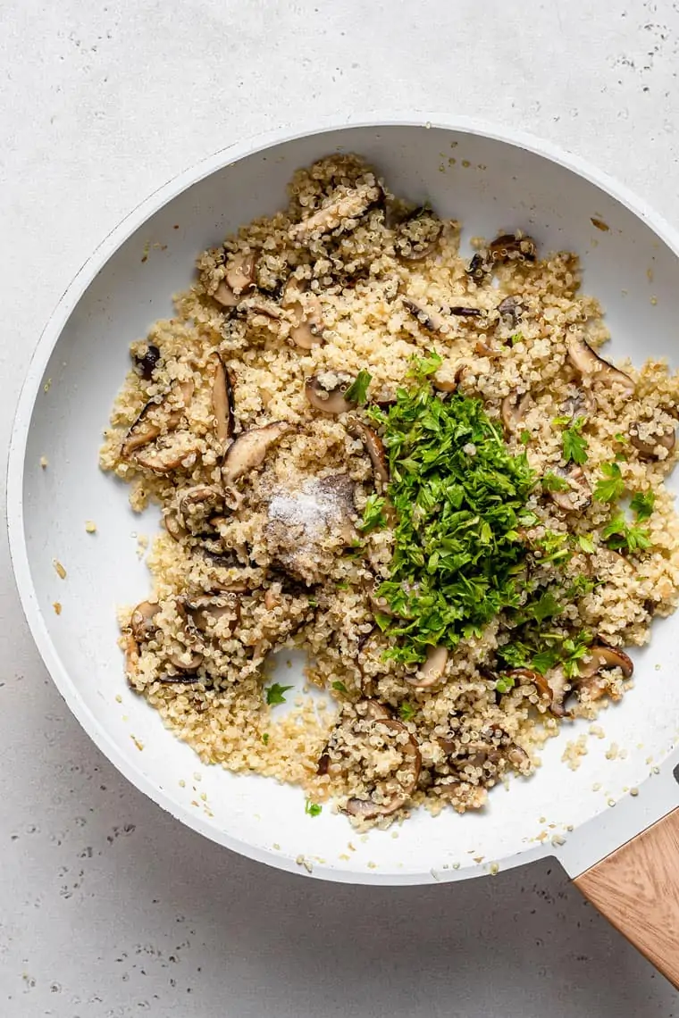 skillet with mushroom quinoa topped with herbs