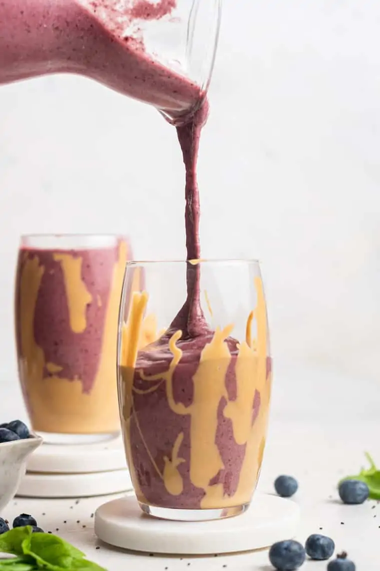 pouring smoothie into a jar with peanut butter