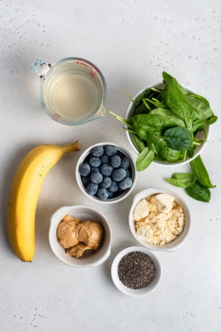 ingredients for smoothies with banana, blueberry, peanut butter and protein powder