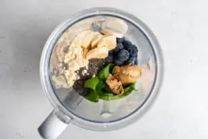 blender with ingredients for peanut butter and jelly smoothie